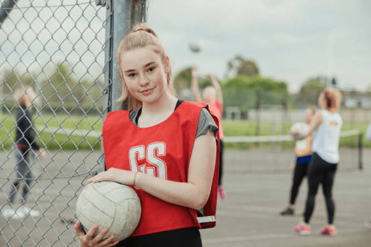 Girl stood holding a netball